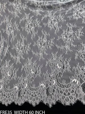 White dyeable Chantilly fine eyelash lace fabric FRE35 featuring delicate floral embroidery, intricate net detailing and fine eyelash edges, 60 inches wide.