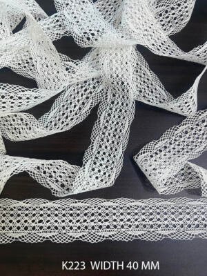 Shop K65 fine white cotton crochet lace with delicate fan motifs and airy openwork. 28 MM wide trim for apparel, kidswear, décor and sewing. Sold per meter.