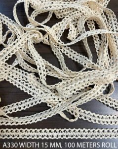 Close-up of A330 cotton dyeable lace trim showing fine knitted texture and undyed griege color