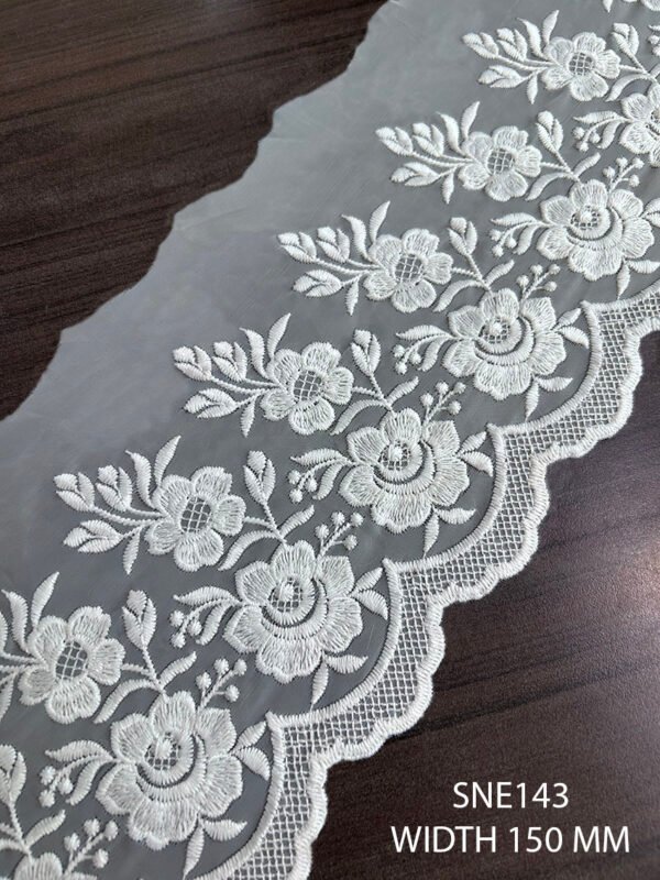 Close-up of SNE143 white polyester net embroidery lace on organza fabric